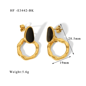 Detail view of gold hoop earrings with black enamel and dimensions 28.5mm by 19mm