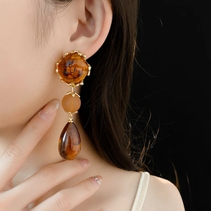 Detail of vintage gold drop earrings with amber faceted stones and waterdrop tassels