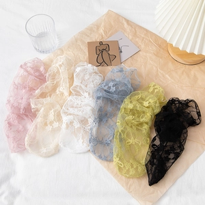 Detailed set of six sheer floral lace socks in various pastel colors on a rustic background
