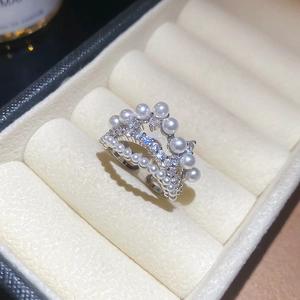 Macro shot of silver crown ring featuring layered pearls and sparkling cubic zirconia stones