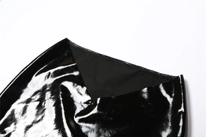 Gros plan détaillé du tissu en latex noir brillant avec coutures précises et texture lisse