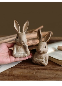 Detailed view of resin rabbit figurines with realistic wood grain texture and vintage finish