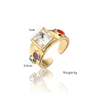 Macro detail of 18K gold-plated ring with large square zircon and colorful gemstones