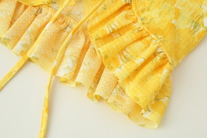 Detailed macro shot of yellow floral fabric with ruffle trim and textured creped finish
