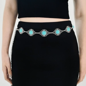 Close-up of bohemian silver waist chain with turquoise stones on a model's dress