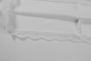Detail shot of delicate white floral lace trim and fine stitching on a dress