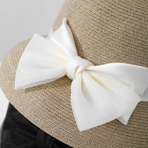 Women's summer straw sun hat with large elegant white ribbon bow for beach vacations