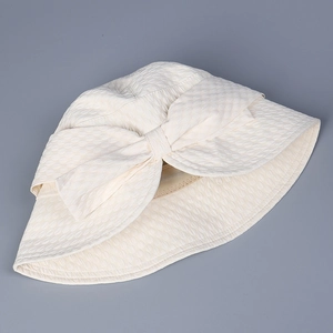 Detail of elegant beige sun hat with textured bubble fabric and a large stylish bow