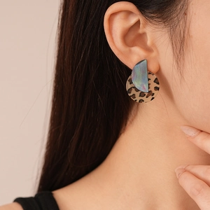Detail of leopard print acrylic geometric earrings with iridescent metallic finish