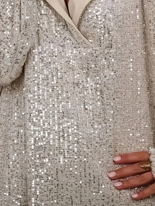 Makroaufnahme der glitzernden Paillettenstruktur an einem lässigen Kapuzenpullover
