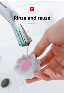 Reusable cat-shaped sponge being rinsed under water for bathroom mirror cleaning