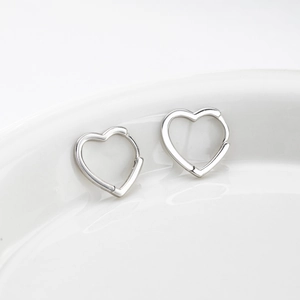 Elegant s925 sterling silver heart-shaped hoop earrings on a minimalist white tray