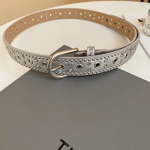 Detail of silver studded leather belt featuring metallic rivets and rhinestone accents