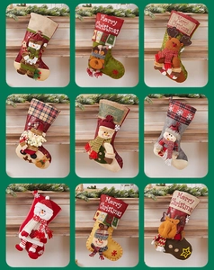 Detail of assorted Christmas stockings featuring plush 3D Santa, deer, and snowman figures