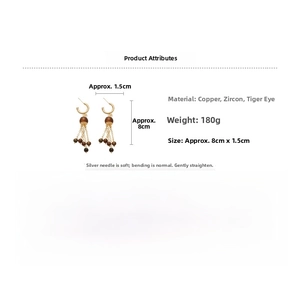 Detail of long gold tassel earrings with brown tiger eye stones and zircon accents