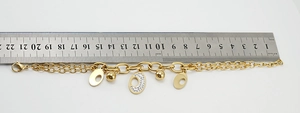Detailed view of 18K gold plated stainless steel layered bracelet showing its length on a ruler