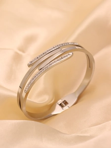 Macro shot of triple-layer silver cuff with micro-pave crystals on silk background