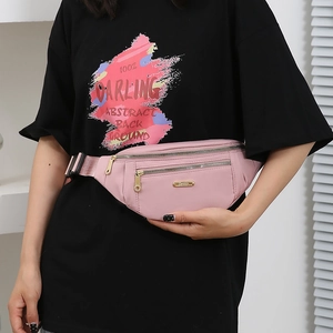 Pink nylon fanny pack with gold zippers and Fashion nameplate worn on black t-shirt
