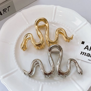 Elegant gold and silver snake shaped metal hair claws with wavy scales for women