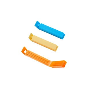 Set of three colorful plastic food sealing clips for snack preservation on white background