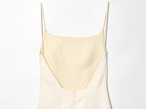 Detail of cream satin slip dress featuring spaghetti straps and low back design