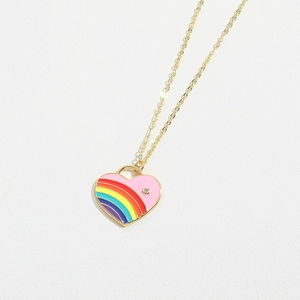 Macro shot of gold-plated rainbow enamel heart pendant necklace on white leather