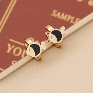 Golden fish-shaped huggie earrings with black enamel inlay on a luxury satin display