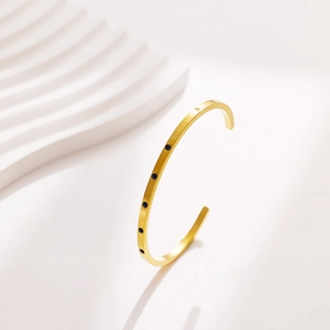 Detail of 18k gold plated titanium cuff bangle with five inlaid blue zircon stones