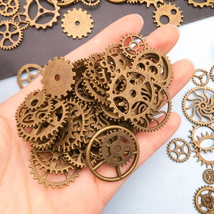 Assorted vintage steampunk gear charms in antique bronze finish held in hand