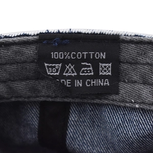 Close-up of the 100% cotton washing label and inner stitching on the denim baseball cap