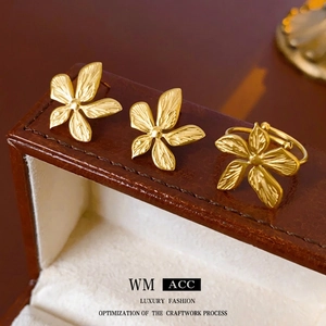 Golden matte flower jewelry set with floral stud earrings and adjustable ring in brushed finish