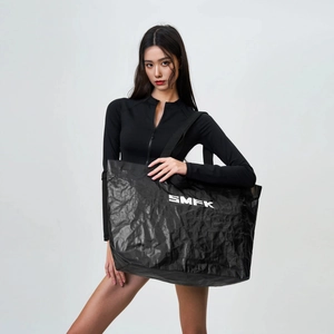 Close-up of black oversized gym bag featuring crinkled texture and white logo print