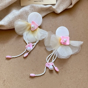 Detail of floral chiffon tassel earrings with shell accents and white pearls