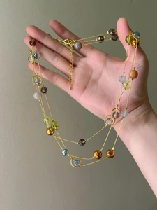 Detail of multi-layer gold chain necklace with colorful faceted stone beads