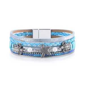 Macro view of blue multi-layer leather bracelet with silver starfish and turtle charms
