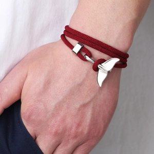 Multi-layer red woven rope bracelet with silver whale tail clasp on wrist