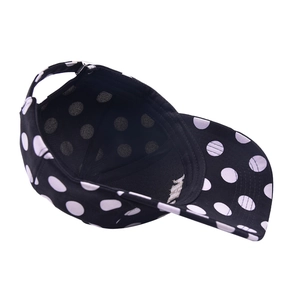 Fashionable black and white polka dot baseball cap with adjustable strap and curved brim