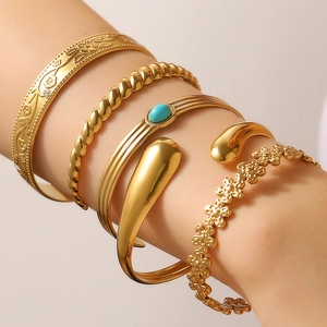 Detailed close-up of a 5-piece gold bangle set with floral and geometric patterns