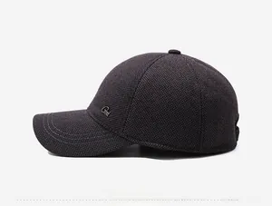 Detail view of winter baseball cap showing dark woven texture and side metal logo