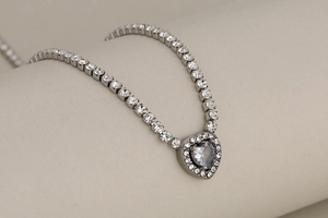 Close-up of heart pendant necklace with shimmering tennis chain and silver finish