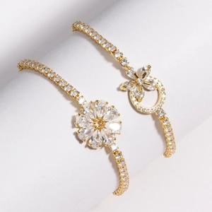 Détail de bracelets plaqués or avec fleurs en zircon et chaînes serties de cristaux