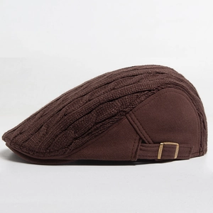 Detail of brown ivy cap showing cable knit pattern and bronze metal adjustment buckle