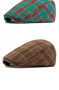 Detail of red-green and coffee plaid ivy caps in vintage tweed texture on white background