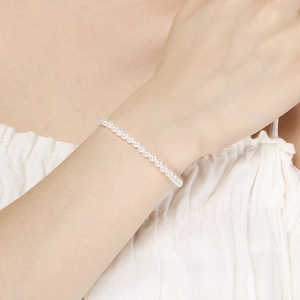 Close-up of 4mm white pearl bracelet on wrist with elegant minimalist design