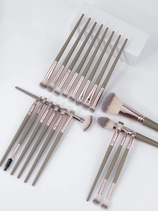 Close-up of 20 professional makeup brushes with sage green handles and rose gold ferrules