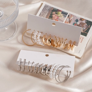 Detail of 12-piece gold and silver geometric twisted hoop earrings set with pearls