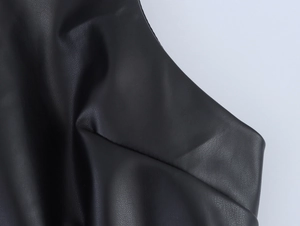 Detailed close-up of high-quality black PU leather fabric with textured pleats and sheen