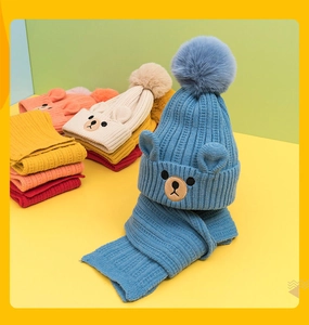 Detail of colorful knitted beanies with bear ears and pom-poms for children