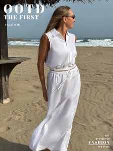 Detailed texture of white linen two-piece set featuring zippered top and maxi skirt