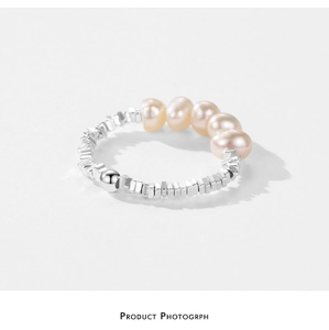 Macro detail of S925 silver beaded ring with five pink natural pearls on white background